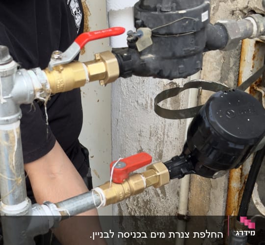 ברזים אדומים וצינורות מתכת בעבודת אינסטלציה